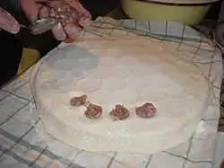 Zuerst wird der Teig auf das Formeisen (sog. Pelmeniza) gelegt und befüllt.