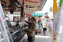 Ein Mann kauft Süßigkeiten an einem Stand auf dem Volksfest