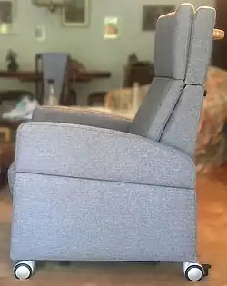 Pflegesessel / ReHa-Sessel mit abnehmbaren Armlehnen, Rollen in privater Umgebung.