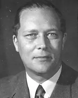 Das Bild zeigt Philipp Alois von Schoeller im Porträt in schwarz-weiß; darauf ist ein Mann Anfang vierzig zu sehen, der die Haare nach hinten gekämmt hat und einen Anzug mit Krawatte trägt.