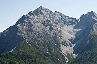 Piz Pisoc (höchster Gipfel), Ansicht von Norden. Links davon die untergeordneten Gipfel von Piz Lavetscha und der Piz Clemgia, rechts davon der etwas kleinere Piz dals Vadès und am rechten Bildrand der Piz Zuort.