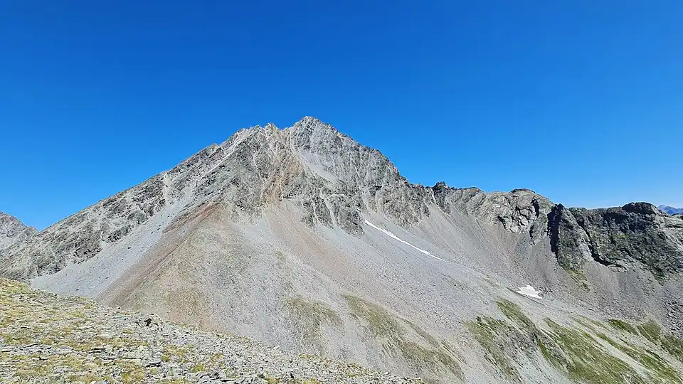 Aus Südwesten: Blick vom Piz Glims zum Piz Linard. Südwestgrat links, Südsüdwestgrat in der Mitte, Normalroute in der Südwand rechts davon und Südostgrat rechts.