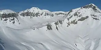 Piz Segnas (Mitte links) von Südost, vom Fil de Cassons. Ganz links Atlas, ganz rechts auf dem gleichen Rücken nur knapp sichtbar der Aufschwung zum Piz Sardona und rechts im Vordergrund Piz Dolf.