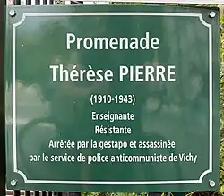 Zu sehen ist eine grüne quadratische Gedenktafel aus Metall in Paris an einem Zaun angebracht. Mit weißer Schrift steht dort:„Promenade Thérèse Pierre (1910-1943) Enseignante, Résistante, Arrête par la gestapo et assassiné par le service de police anticommuniste de Vichy“ Übersetzt heißt es:„Thérèse Pierre Promenade (1910-1943) Lehrerin, Widerstandskämpferin, verhaftet von der Gestapo und ermordet von der antikommunistischen Polizei von Vichy.“