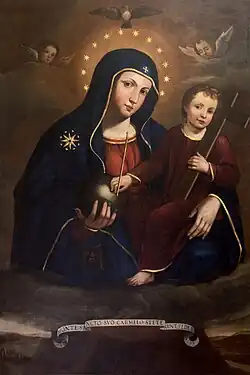 Über den Wolken schwebende Madonne mit Sternenkranz, blauem Kapuzengewand, rotem Untergewand. Sie hat eine Kugel in der rechten Hand, das bereits ältere Jesuskind mit dunkelrotem Gewand im linken Arm. Dieses hält ein Holzkreuz und berührt ebenfalls die Kugel. Oberhalb zwei schwebende Putten und eine Taube als Symbol des Heiligen Geistes. Unterhalb ein geschwungenes Spruchband