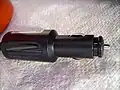 Stecker für Zigarettenanzünder nach Norm SAE&nbsp;J563 (passt nicht für ISO&nbsp;4165). Im Griff dieses Steckers ist ein Spannungsadapter eingebaut, der die 12 Volt auf eine geringere Spannung reduziert.
