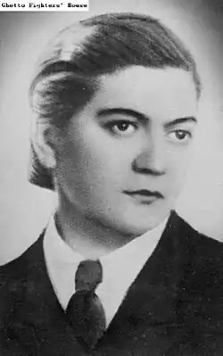 junge Frau mit schwarzem, glattem, zurückgekämmtem Haar und ernstem, festen Blick