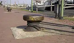 Trossen aus Stahlseil und Pflanzenseilen um einen Poller