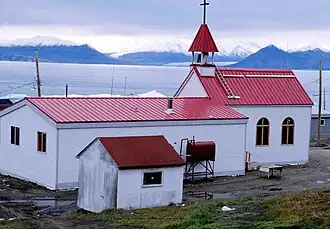 Nach dem verheerenden Brand von 1994 neu errichtete katholische Kirche von Pond Inlet; auf der gegenüberliegenden Seite des Eclipse Sound: Bylot Island