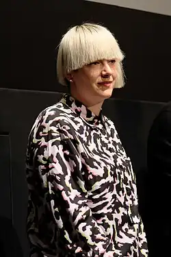 "Regisseurin und Kameramann stellen sich vor einer Kinoleinwand den Fragen des Publikums"