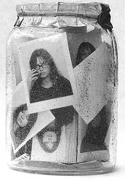 Nahaufnahme eines Einmachglases, das verschiedene Passfotos der Künstlerin zeigt.