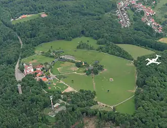 Potzbergkuppe mit Post- und Aussichtsturm sowie Bundeswehrturm, „Burg“ (Hotel) und Wildpark, rechts oben die Gemeinde Föckelberg