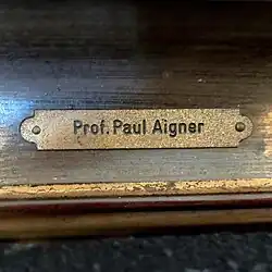 Bilderrahmen aus Holz mit einer Plakette, auf der Professor Paul Aigner steht
