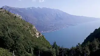 Blick vom Sattel Bocca Larici nach Süden zum Gardasee, links die Punta Larici. Auf der gegenüberliegenden Seite ist das Monte-Baldo-Massiv zu erkennen.