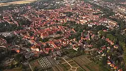 Luftaufnahme der Altstadt von Quedlinburg mit dicht stehenden Fachwerkhäusern, historischen Gebäuden und umgeben von grünen Flächen und Feldern
