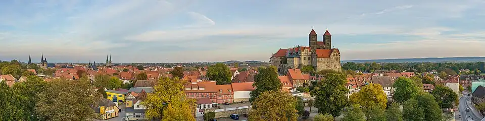 Panoramablick auf Quedlinburg mit Fachwerkhäusern und der Stiftskirche auf dem Münzenberg unter blauem Himmel