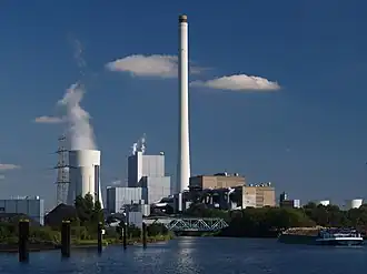 Oberwasser der Anlage, rechts ein Frachter mit Holzschnitzeln, im Hintergrund das Steinkohlekraftwerk der Steag