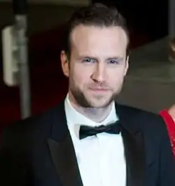 Gesicht von vorn ab Brustkorb mit sichtbarem weißem Hemd nebst Fliege im Smoking in Farbe.