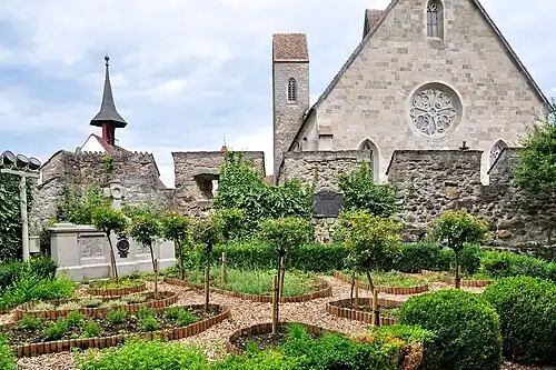 Kräutergarten auf der Ostseite, im Hintergrund die Stadtpfarrkirche. Links ein polnisches Denkmal, darüber der Glockenturm der Liebfrauenkapelle.