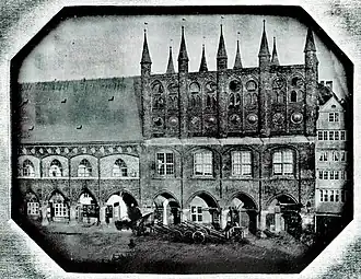 Daguerreotypie vor 1847 von J.&nbsp;W.&nbsp;Pero: Langes Haus mit Spitzbogenfenstern des Verbindungsgangs in zugemauerten breiten Fenstern des vormaligen Löwensaals