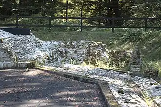 Rekonstruierter Fußboden; die Fassung der Außenmauer ist mit Betonsteinen angedeutet.
