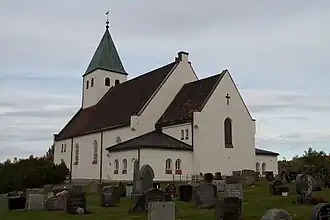 Foto einer gemauerten Kirche mit Friedhof