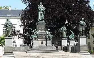 Reformationsdenkmal in Worms, 1868. Konventionelle Denkmalanlage mit statuarischer Figurenanordnung.[25]