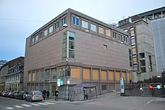 Foto eines Bürogebäudes, die Fenster teilweise durch Holzplatten ersetzt