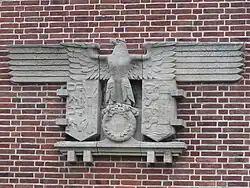 Entnazifizierter Reichsadler mit den Wappen Schleswig-Holsteins und Flensburgs unter den Schwingen, an der Marinesportschule in Flensburg-Mürwik, wo im Mai 1945 die letzte Reichsregierung verhaftet wurde.