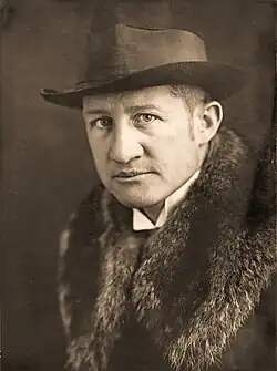 Ein schwarz-weiß-Portraitfoto von Richard Paulus mit Hut und Pelzkragen