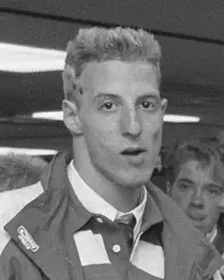 Ron Dekker trägt auf diesem Schwarzweißfoto ein Hemd mit Krawatte und eine Windjacke.