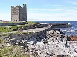 Rosslee Castle mit dem Pier und der Steinküste