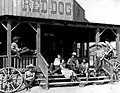 Roy Rogers (rechts an der Säule lehnend) mit anderen Schauspielern in den 1950er Jahren. Der Red Dog Saloon brannte im April 1966 ab.[22]