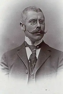 Rudolf von Scala mit Klemmbrille, langem Schnurrbart, dunkler Krawatte und Anzug