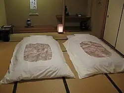 Futons und Andon im Hintergrund in einem Ryokan