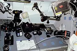 Verschieden Kameras und Objektive, Stative, Blitzlichter, Batterien bzw. Akkus und sonstiges Zubehör.