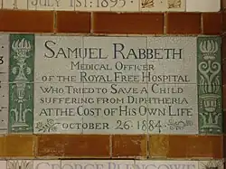 A tablet formed of six standard sized tiles, bordered by green flowers in the style of the Arts and Crafts movement