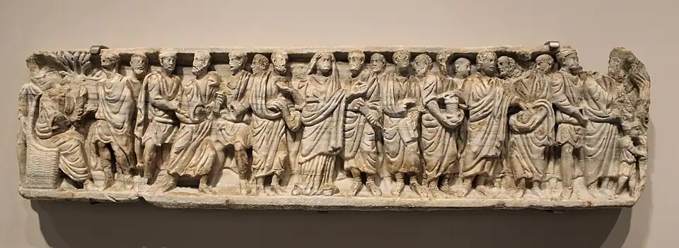 Teil eines Marmorsarkophags, 4. Jh. Im Gegensatz zur üblichen Darstellung der Zeit sind die Figuren hier nicht durch Bäume getrennt. Das Fragment wurde bei einem Narbonner Haus wieder verwertet.