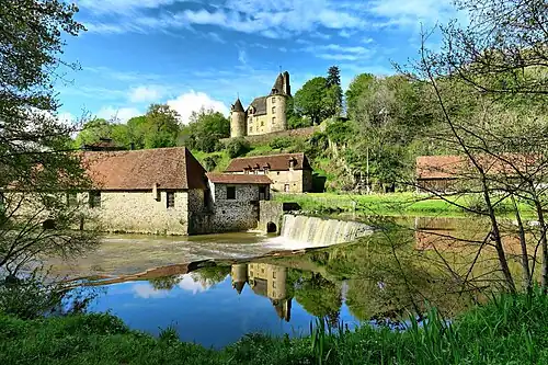 Die Schmiede La Forge mit Nebengebäuden an der Auvézère, darüber das Schloss