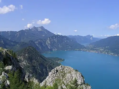 Gemeindegebiet Unterach: Mitte rechts, am Attersee, die Ortschaft, dahinter die Ortsteile Au/See am Mondsee, links Burgau am Attersee (St. Gilgen). Blick vom Schoberstein (1037 m, Höllengebirge), nach Westen gegen Schafberg (links, 1782 m) mit Ackerschneid und Kienbergwand (Mitte) und Drachenwand/Schober (rechts) sowie Hochplettspitz (ganz rechts)