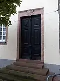 Eingang zum Wohnhaus mit Wappen über dem Sturz
