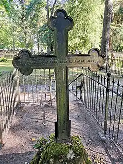 Grab auf dem Friedhof Tartu (Raadi kalmistu) und die Inschrift auf der Rückseite des Grabkreuzes