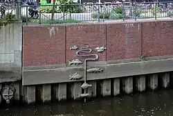 Diese Wasserstandsanzeige zeigt je nach Tide sieben heimische Fisch-Skulpturen.