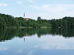 Schloßsee vom Park von Schloss Hartmannsberg, im Hintergrund die Kirche von Stephanskirchen