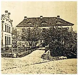 Historische Ansicht um 1900ː Nordfassade bzw. Torhaus mit ursprünglichen Gauben und Kaminen