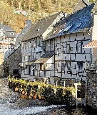 Rurseite des Schmitzenhofes (Fachwerkhäuser, rechts) mit Absperrschieber für den Mühlengraben mit Wasserrad am Ende