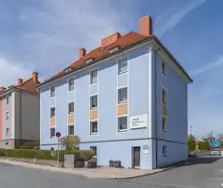 Foto zeigt türkises Haus schief von vorne