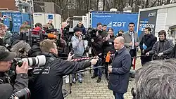 Mann umringt von Journalisten