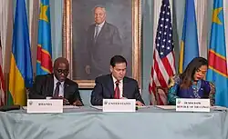 Drei Menschen unterzeichnen an einem Tisch sitzend Dokumente