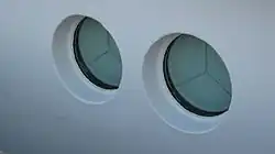 Innen heruntergeklappte Seeschlagblenden zur Sicherung der Bullaugen der Spiekeroog&nbsp;I (Sicht von außen)